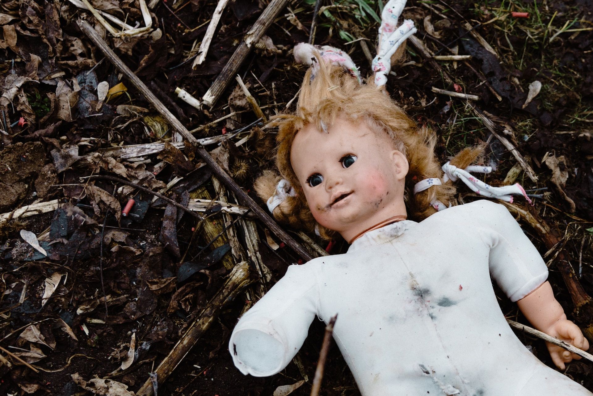 poupée abîmée et salie dans la nature - Photo by Artem Maltsev on https://unsplash.com/fr/photos/fille-en-chemise-blanche-a-manches-longues-couchee-sur-des-feuilles-sechees-o0DSot0OSjU