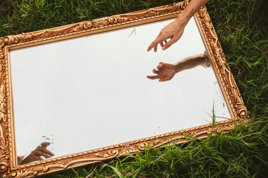 Allusion à la création de l'humain par Michel-Ange : un miroir révèle que nous sommes créés par Dieu et que cette création est en cours - Photo de Chase Kennedy sur https://unsplash.com/fr/photos/une-personne-tendant-la-main-pour-toucher-un-miroir-uvmTg80KJ4o