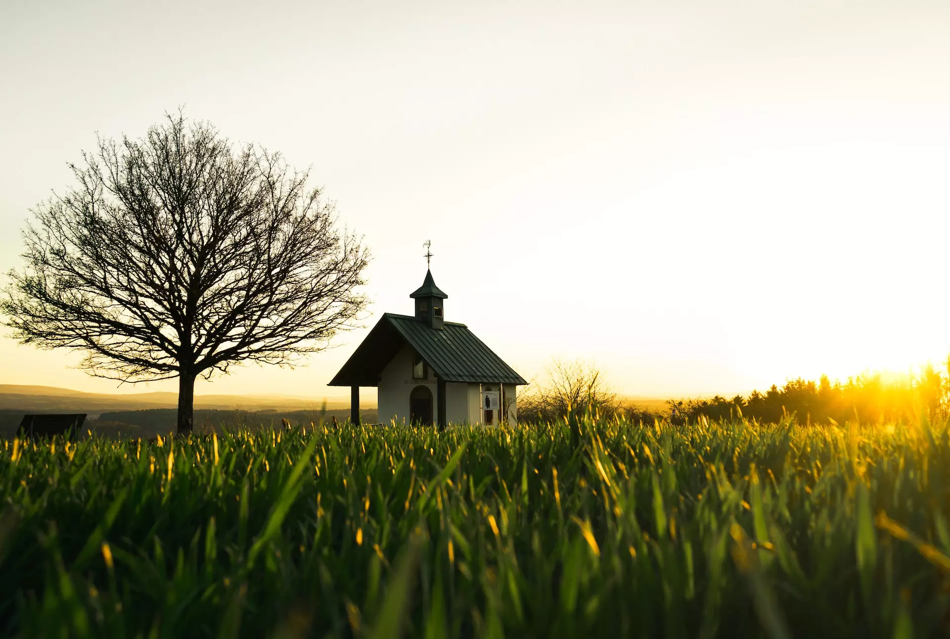 l'image d'une église dans un champ d’herbe verte pendant la journée - Photo de Subhasish Dutta sur https://unsplash.com/fr/photos/maison-en-bois-marron-sur-un-champ-dherbe-verte-pendant-la-journee-K8Brtpkzjxw