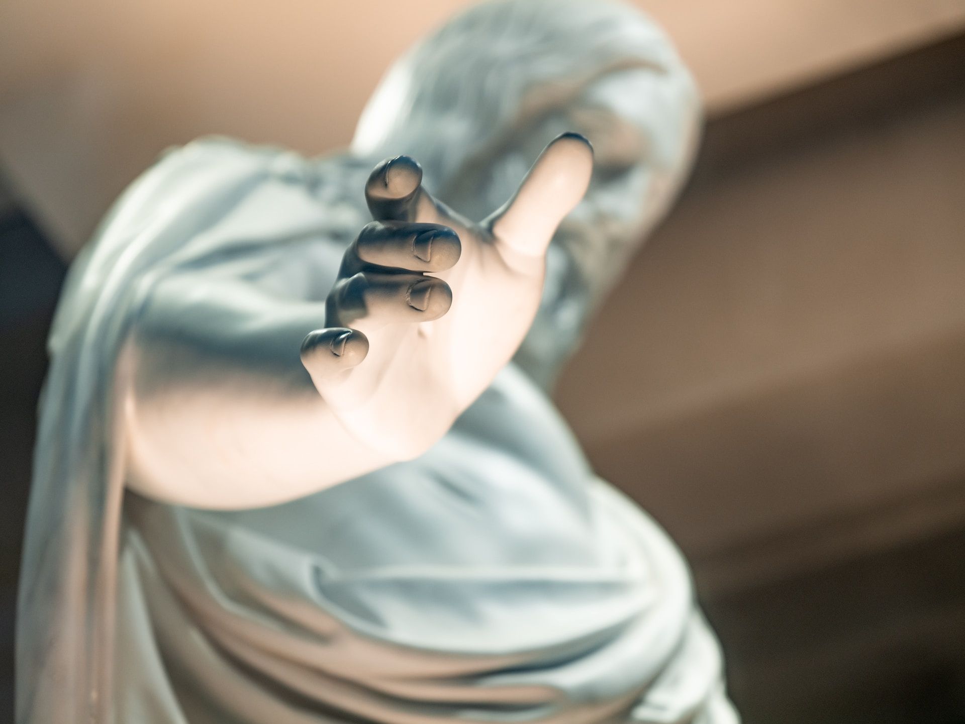 une statue imaginant Jésus, avec sa main tendue en gros plan - Photo by the blowup on https://unsplash.com/fr/photos/garcon-en-chemise-blanche-portant-des-lunettes-a-monture-noire-CuOZuiZDBWU
