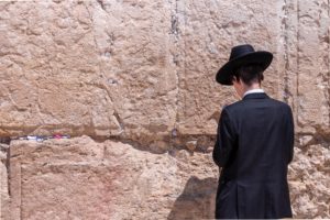un jeune juif priant au mur des lamentations - Photo by Joshua Sukoff on Unsplash