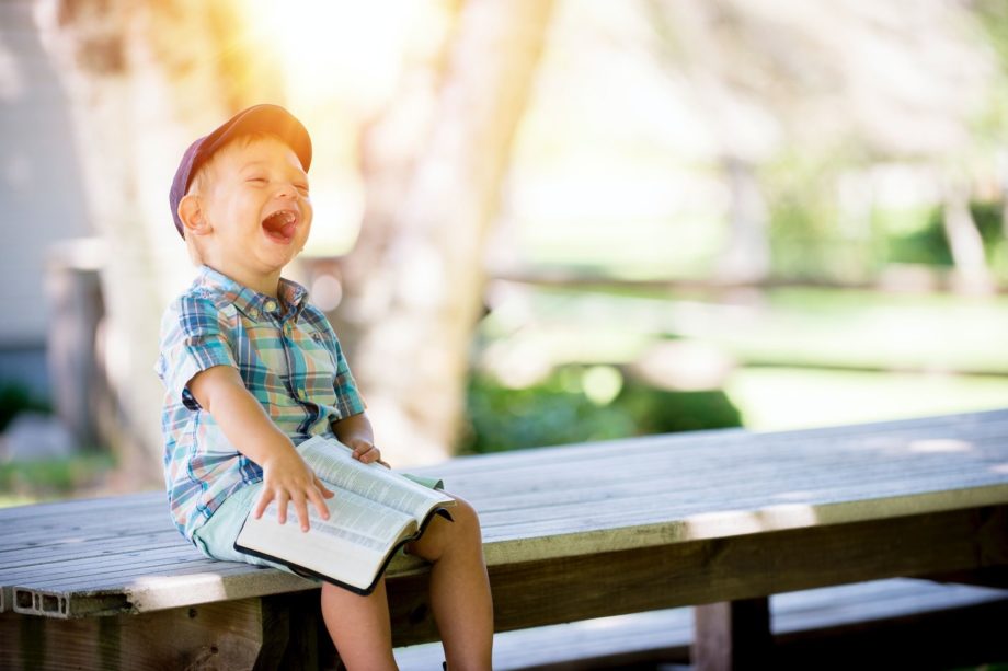 enfant éclattant de rire, une bible sur les genoux - Photo by Ben White on https://unsplash.com/fr/photos/4K2lIP0zc_k