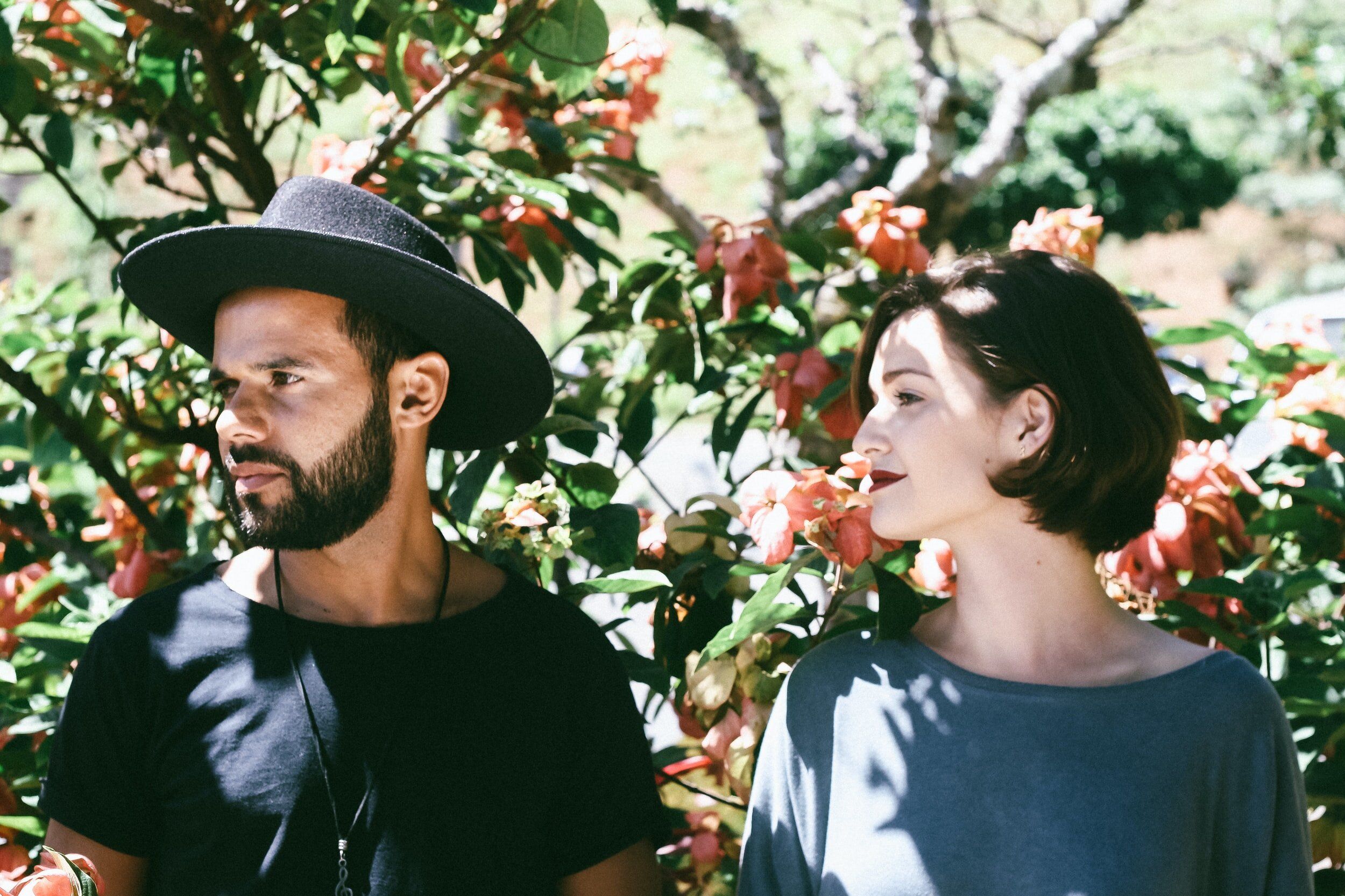 un homme portant un chapeau et une femme dans un jardin - Photo by Matheus Ferrero on Unsplash