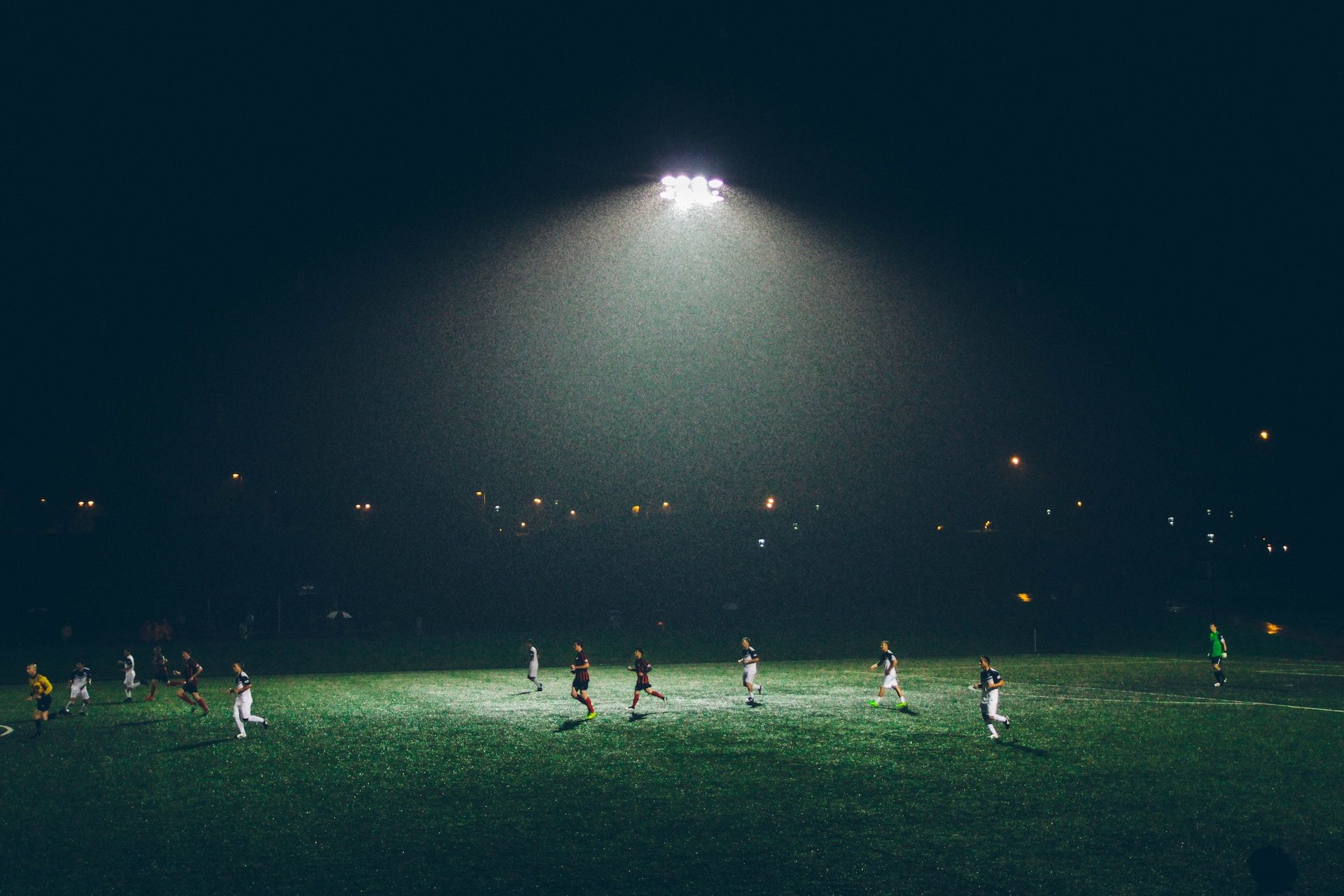 une partie de foot en soirée, sou sle feux des lampes - Photo by Abigail Keenan on https://unsplash.com/fr/photos/8-s5QuUBtyM
