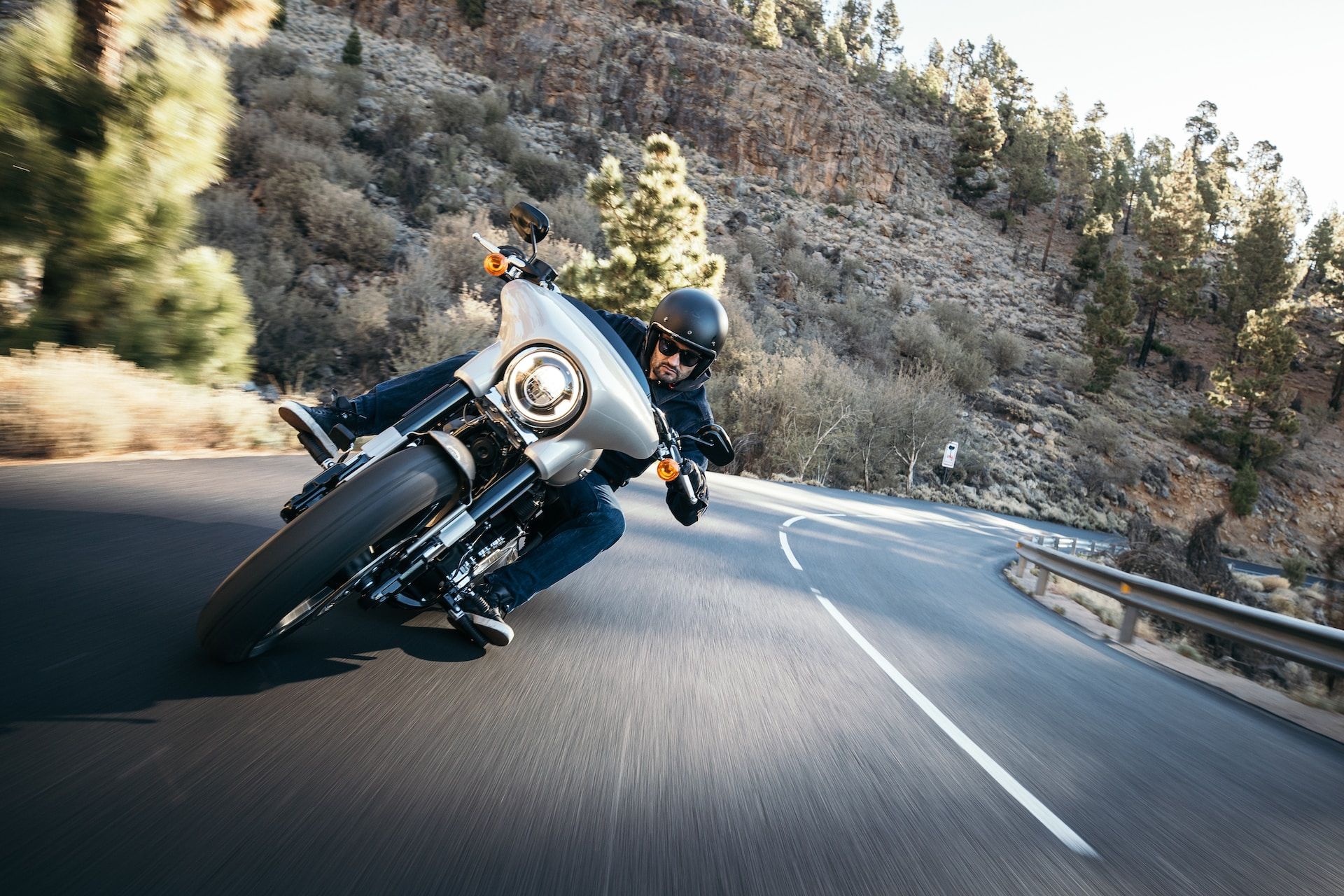 un homme en grosse moto roulant vite dans un virage, venent vers nous - Photo by Harley-Davidson on https://unsplash.com/fr/photos/wdc9ZAiwBB4