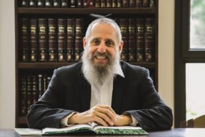 Un rabbin souriant devant des livres -  Image par rabbijacobs de Pixabay 