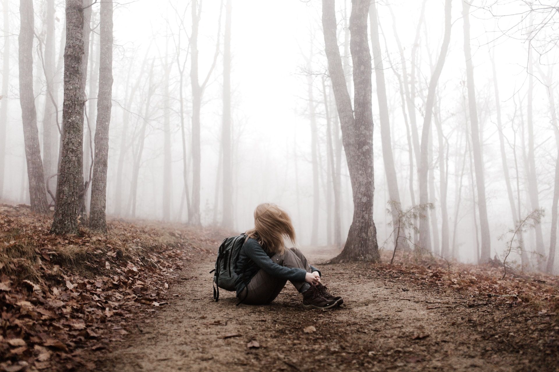 jeune femme assise sur le chemin en forêt - Photo by Andrew Neel on https://unsplash.com/fr/photos/KkCig7EbfoA