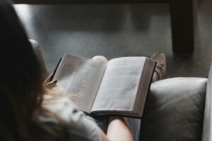 Une femme lit et interprète sa Bible par elle même - Photo de Alexandra Fuller sur https://unsplash.com/fr/photos/personne-lisant-un-livre-sur-un-canape-en-cuir-noir-Ju7LlnTZCrw