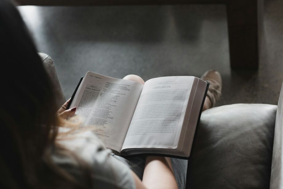 Une femme lit et interprète sa Bible par elle même - Photo de Alexandra Fuller sur https://unsplash.com/fr/photos/personne-lisant-un-livre-sur-un-canape-en-cuir-noir-Ju7LlnTZCrw