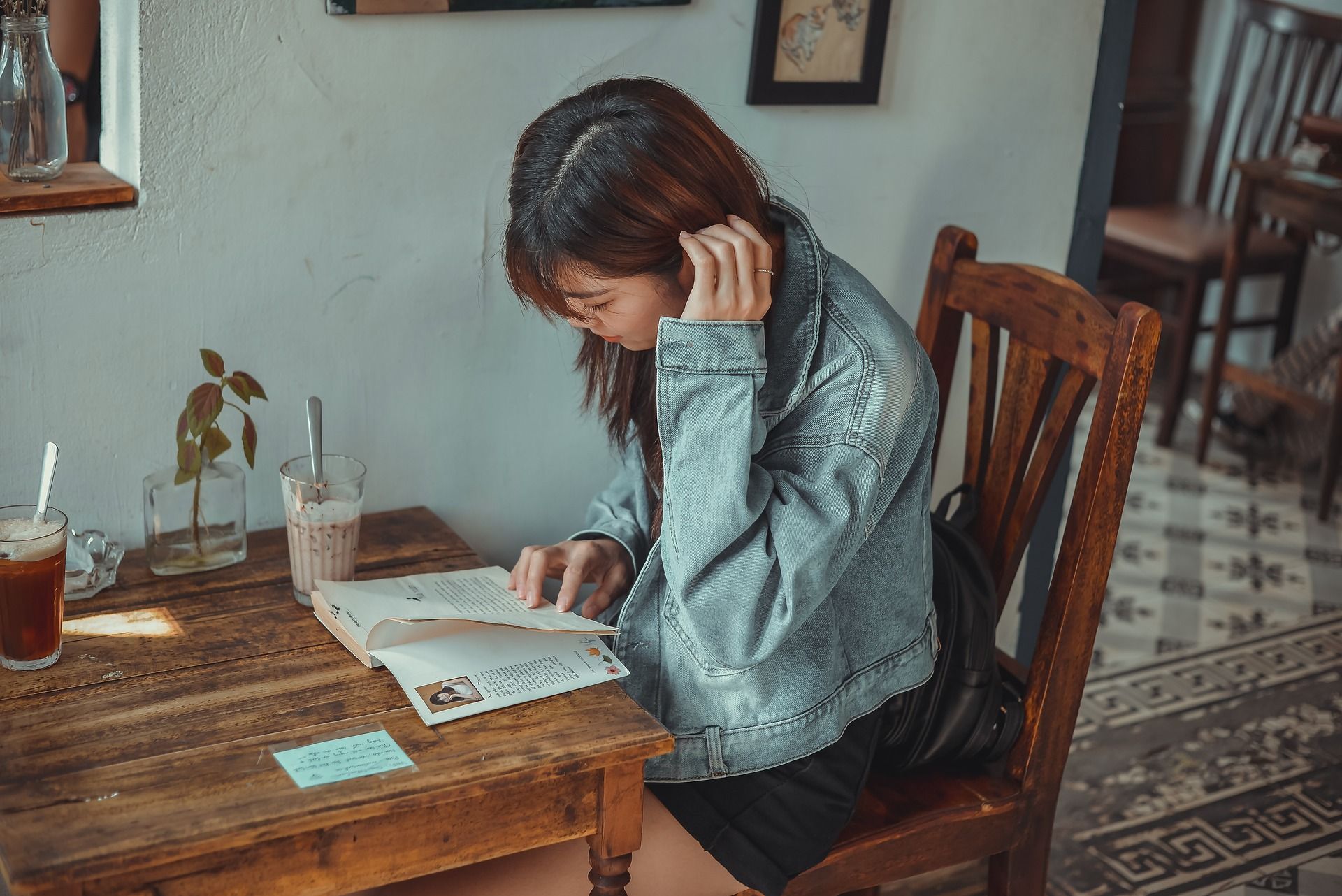 une étudiante lit un livre dans une cafétéria, Image par hoahoa111 de https://pixabay.com/fr/photos/caf%C3%A9-fille-livre-en-train-de-lire-5972490/