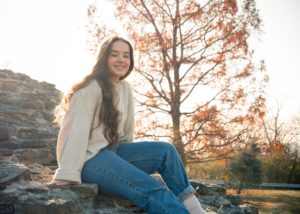 jeune fille souriante assise sur un rocher - Photo by Matt Koffel on Unsplash