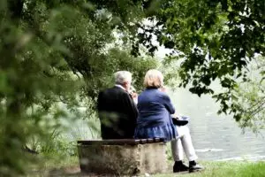 couple âgé assis sur un banc devant un lac - Photo by Sven Mieke on Unsplash 
