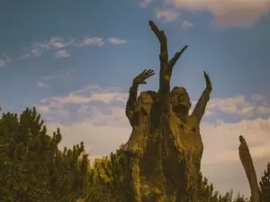 étrange sculpture de deux personnes levant les bras au ciel dans la forêt - Photo by Ramazan Tokay on https://unsplash.com/photos/8Mv47i4a6UI 