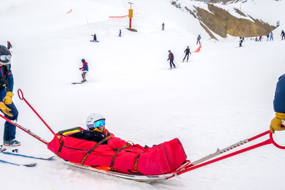 Deux pisteurs secouristes portent secours à un enfant blessé - Photo de Ed Wingate sur https://unsplash.com/fr/photos/une-patrouille-de-ski-sauve-un-skieur-blesse-sur-un-traineau-YgNero3ER0I