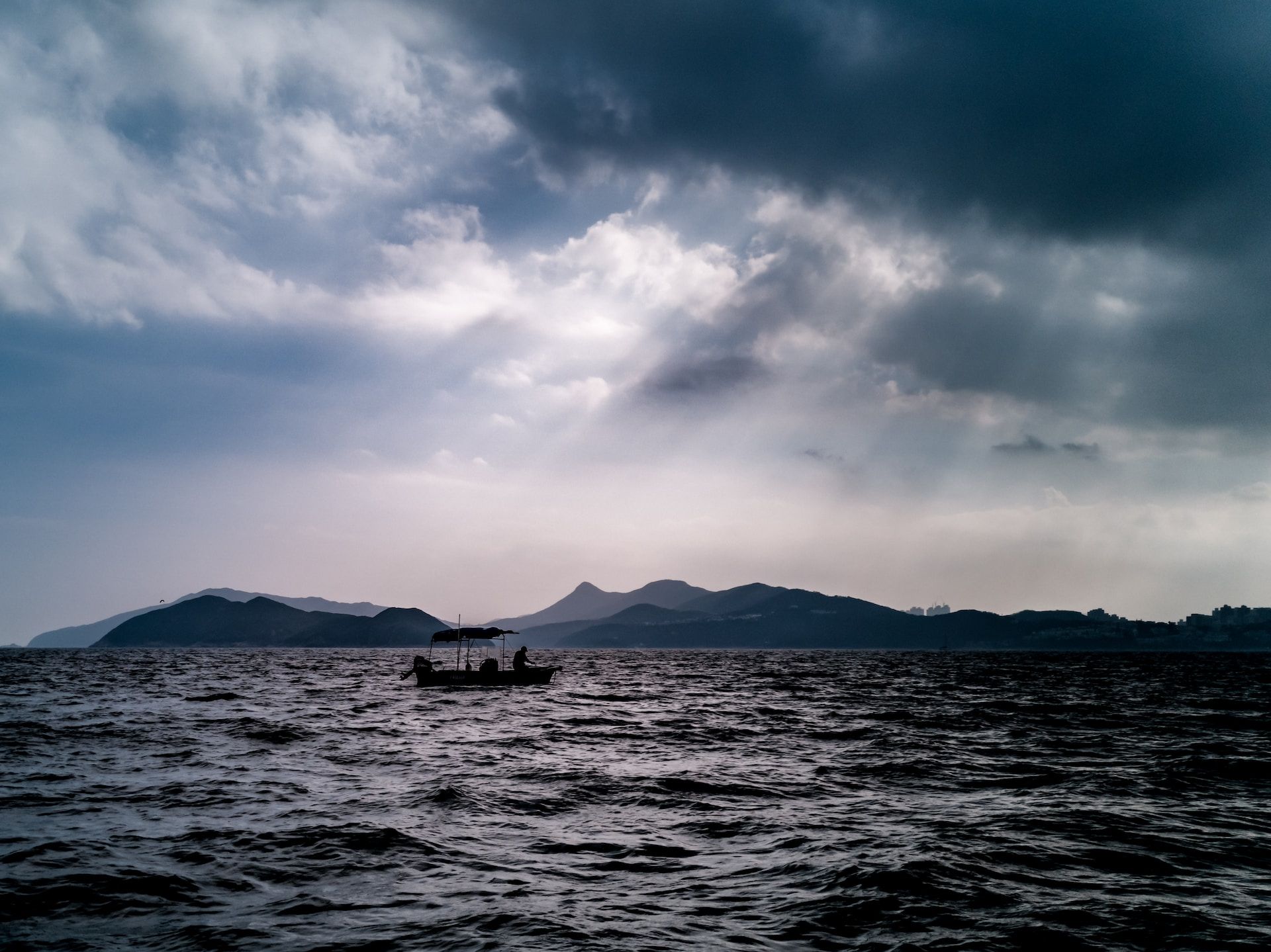 bateau de pêcheur sur la mer avec un orage qui arrive - Photo by Wai Siew on https://unsplash.com/photos/aV44liX_9zg