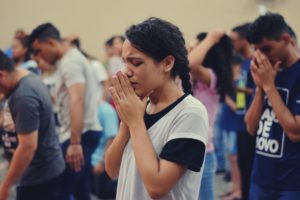 Une femme priant silencieusement dans une assemblée chrétienne - Photo by Igor Rodrigues on https://unsplash.com/photos/tQruu8CRHCw 