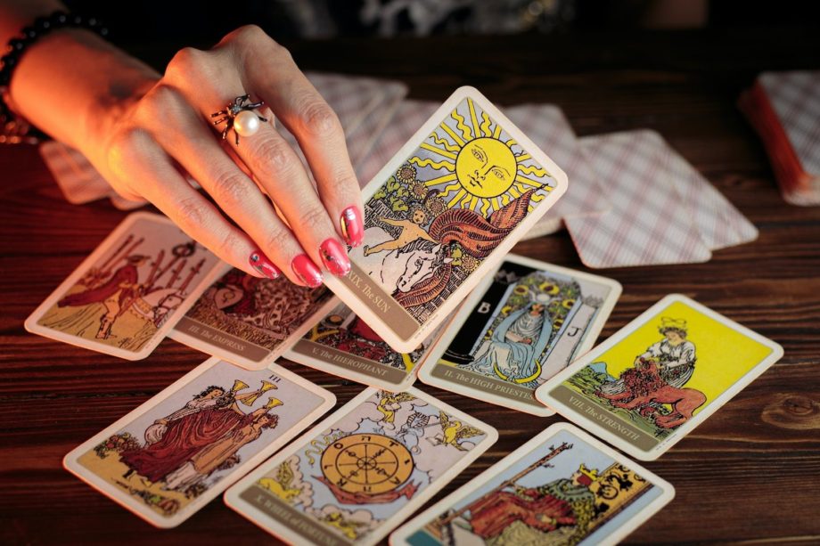 Une main de femme utilisant des cartes de tarrot - Photo by petr sidorov on https://unsplash.com/photos/D3SzBCAeMhQ