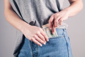 Une jeune femme sort une liasse de billets de sa poche - Photo by Sasun Bughdaryan on https://unsplash.com/photos/oWrRxo9UdM4
