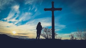 Une femme devant une croix - Photo de Jametlene Reskp sur https://unsplash.com/fr/photos/1VG0lfc1KZI 