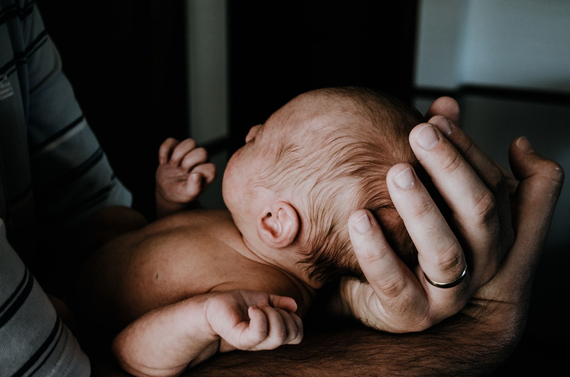 un nouveau né dans les bras de son père - Photo de Kelly Sikkema sur https://unsplash.com/fr/photos/V106bb1a9BY