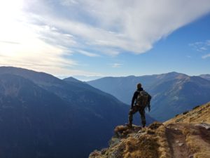 un homme sur un chemin de montagne fait une pause pour regarder le panorame - Photo de Wojciech Then sur https://unsplash.com/fr/photos/DijA5f0voGQ