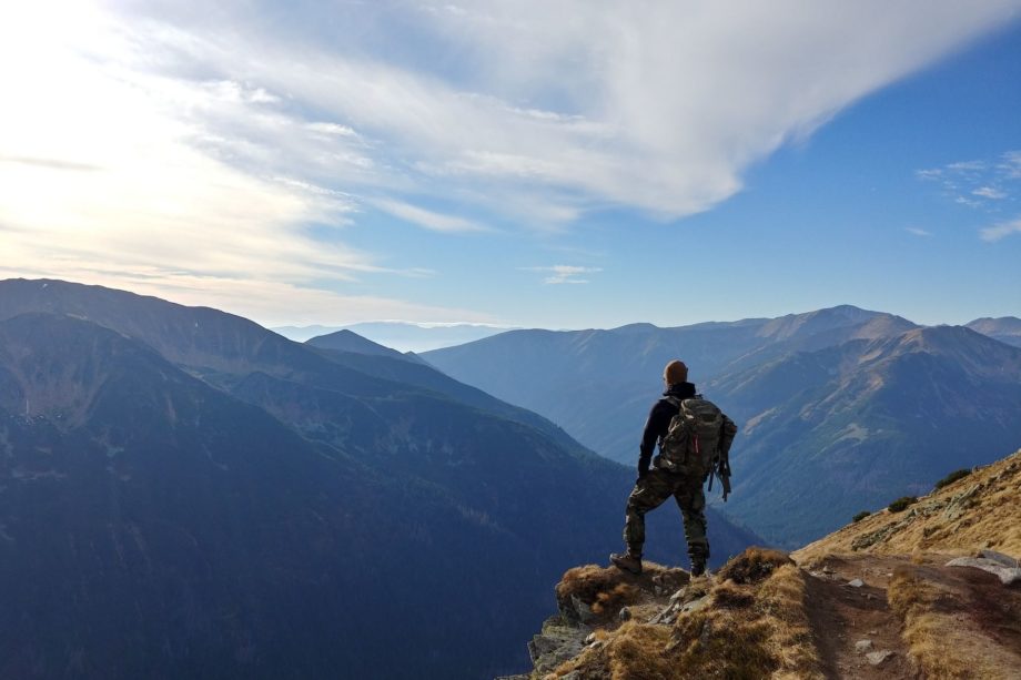 un homme sur un chemin de montagne fait une pause pour regarder le panorame - Photo de Wojciech Then sur https://unsplash.com/fr/photos/DijA5f0voGQ