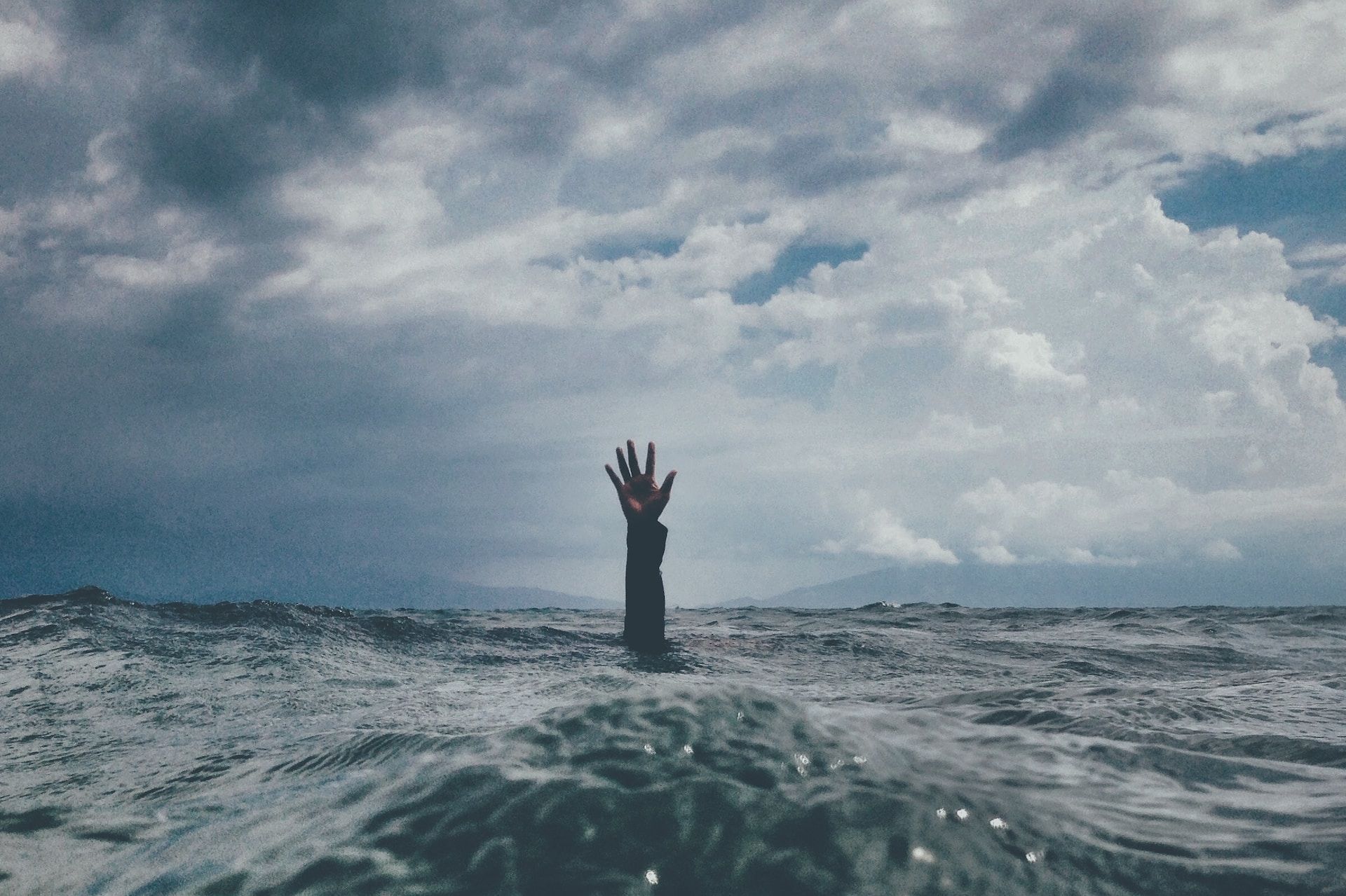 Une main tendue vers le ciel du fond de l'eau - Photo de nikko macaspac sur https://unsplash.com/fr/photos/6SNbWyFwuhk
