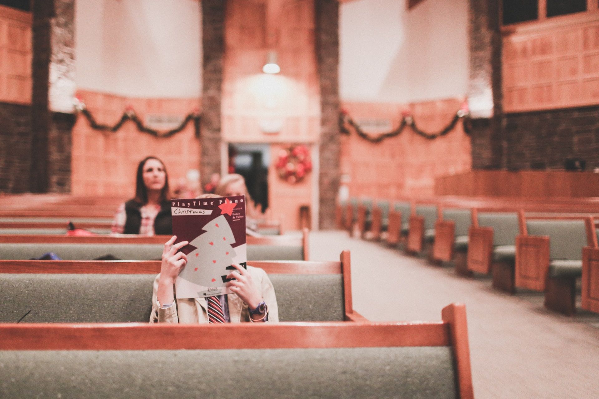 une ou deux personnes en train de lire un programme dans une église vide - Photo de Katie Treadway sur https://unsplash.com/fr/photos/mUsvve8GbHo