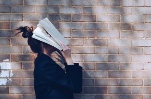 Une femme marche avec un livre appliqué sur ses yeux - Photo de Siora Photography sur https://unsplash.com/fr/photos/hgFY1mZY-Y0