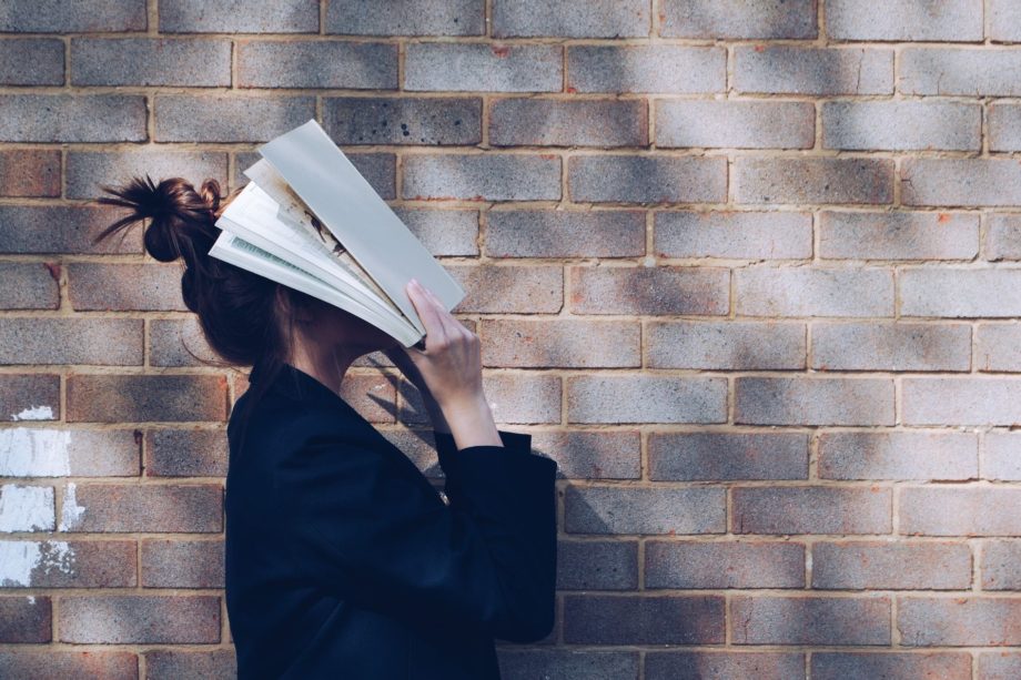 Une femme marche avec un livre appliqué sur ses yeux - Photo de Siora Photography sur https://unsplash.com/fr/photos/hgFY1mZY-Y0