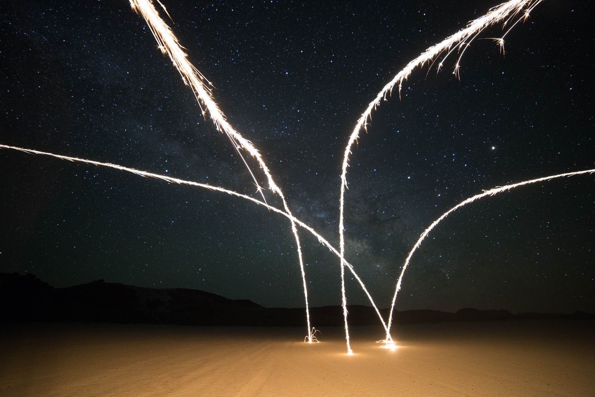 sorte de jaillissement de lumière ou d'eau dans le désert, de nuit - Photo de Meg Nielson sur https://unsplash.com/fr/photos/hcks1gMxUd4