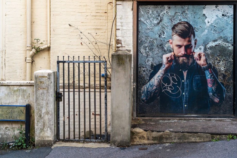 grille, mur et affiche montrant un homme farouche avec moustache - Photo de Nick Fewings sur https://unsplash.com/fr/photos/QuQ8B5gmRXY
