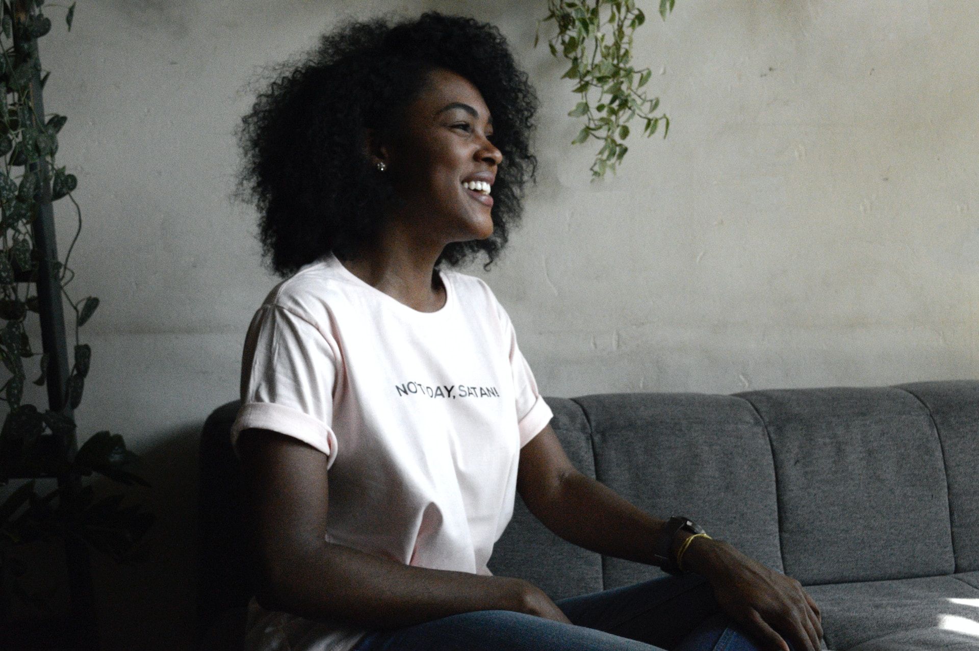 femme noire joyeuse assise sur un canapé - Photo de DISRUPTIVO sur https://unsplash.com/fr/photos/DokE5D4GbDk