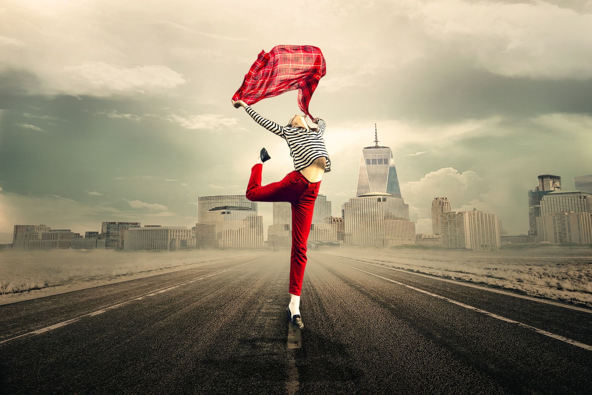 Une femme dansant avec un foulard sur un fond d'immeubles au loin - Image par Myriams-Fotos de https://pixabay.com/fr/photos/libert%C3%A9-femme-route-ville-content-2940655/