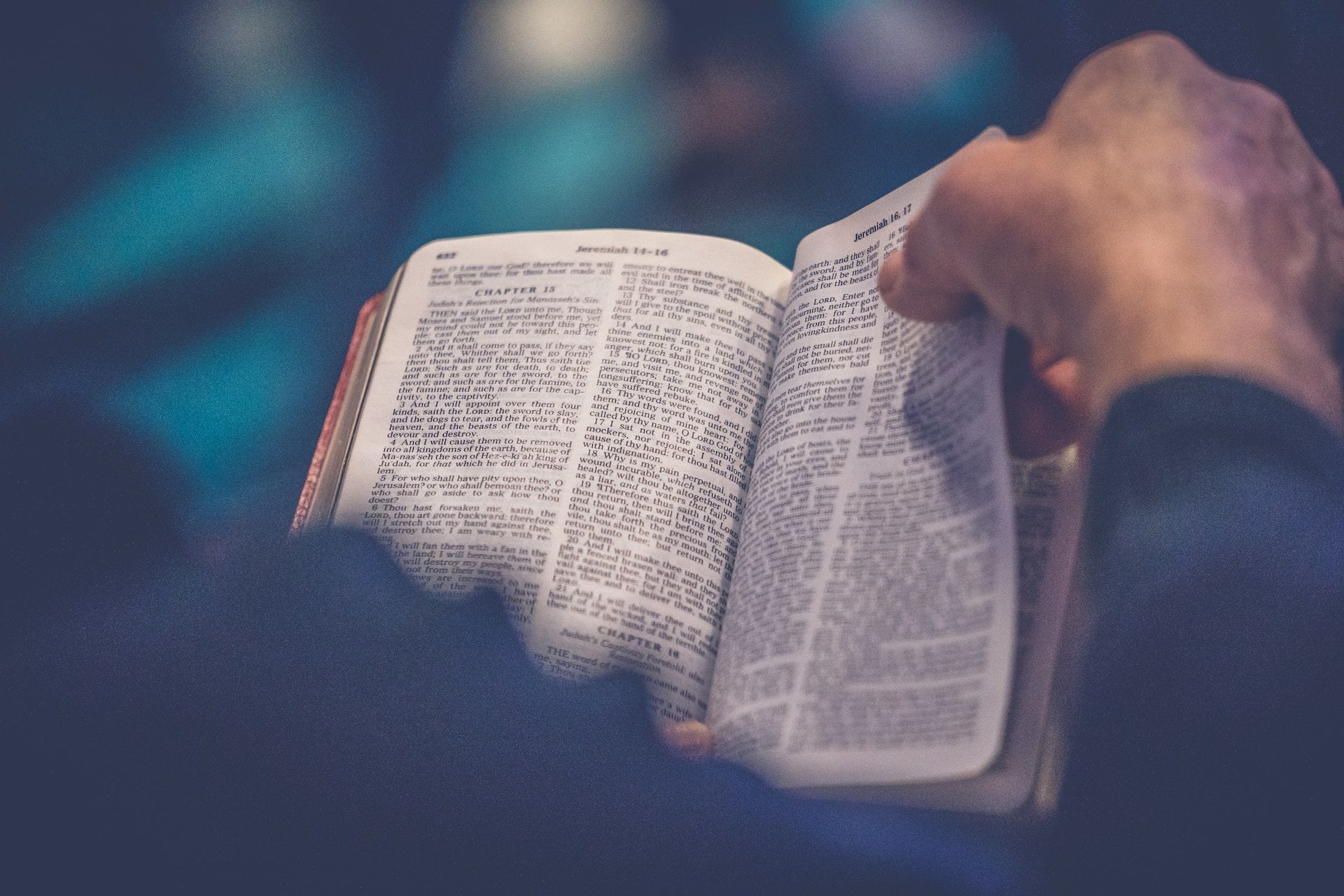 Une Bible en train d'être lue, avec une main qui tourne la page - Photo de Rod Long sur https://unsplash.com/fr/photos/DRgrzQQsJDA