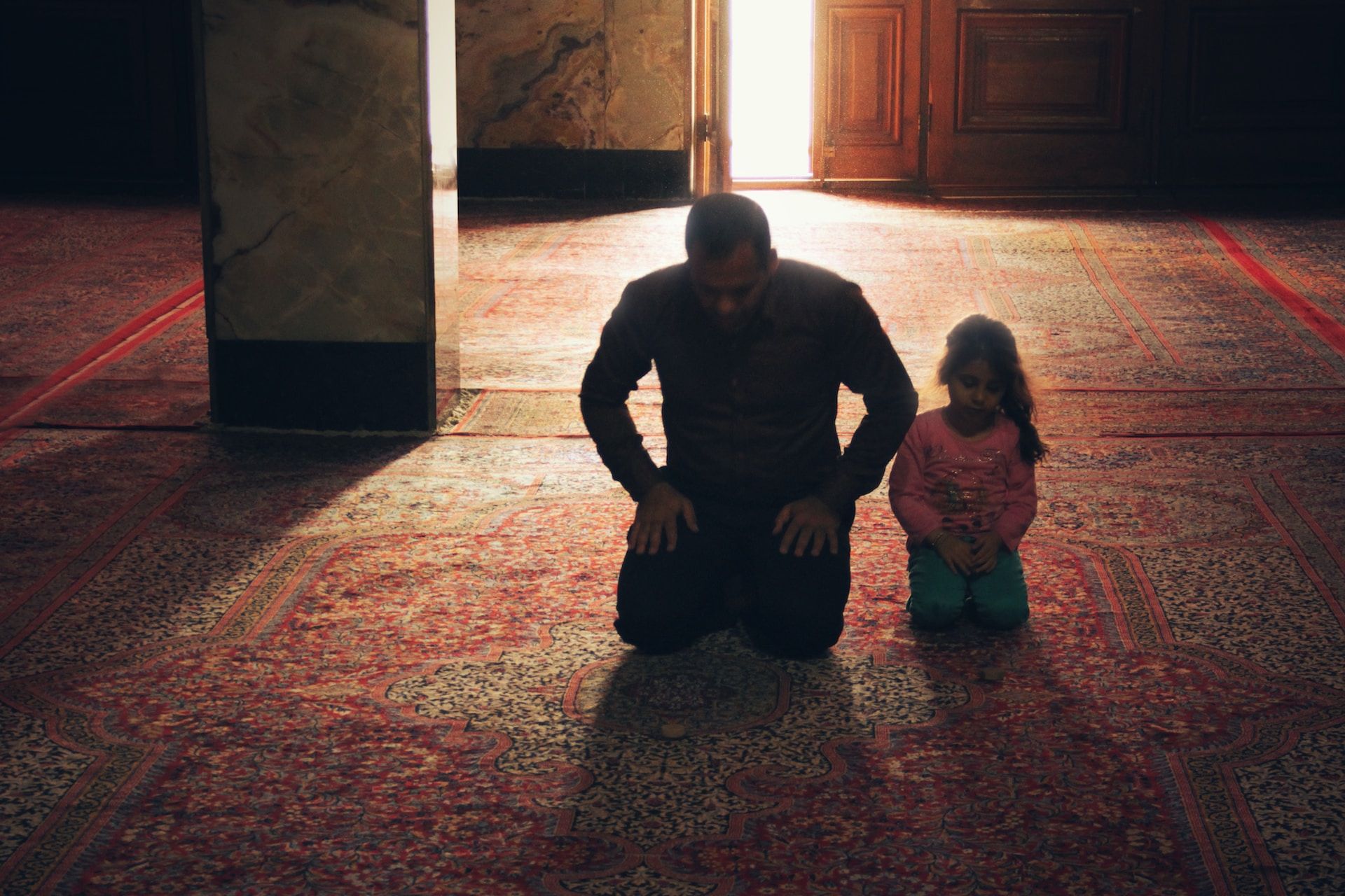 Un p^ère et sa fille priant dans une mosquée - Photo de Hasan Almasi sur https://unsplash.com/fr/photos/kPWfbe65lb4