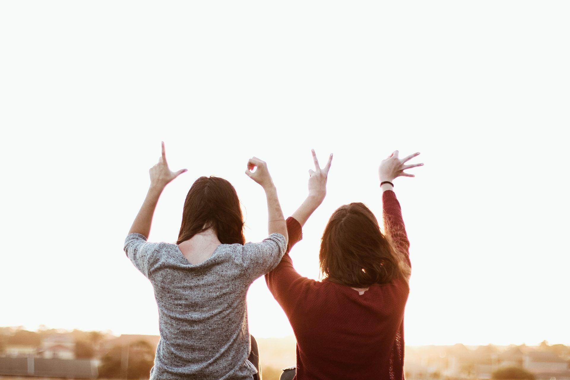deux sœurs vues de dos font des gestes de bras ensemble - Photo de Sincerely Media sur https://unsplash.com/fr/photos/01tbPwcWFWM