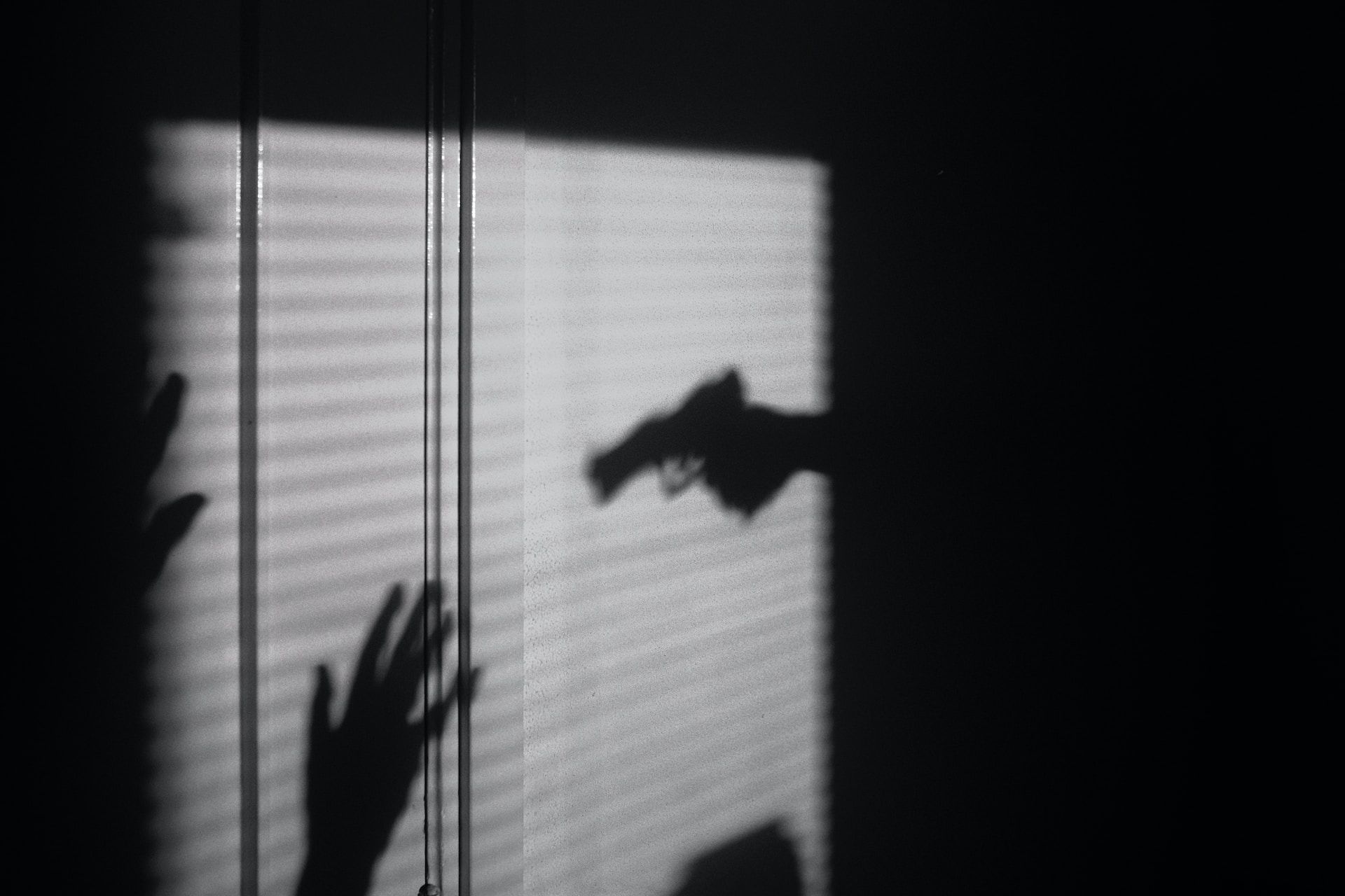 Ombre d'une main tenant un pistolet menaçant une victime - Photo de Maxim Hopman sur https://unsplash.com/fr/photos/PEJHULxUHZs