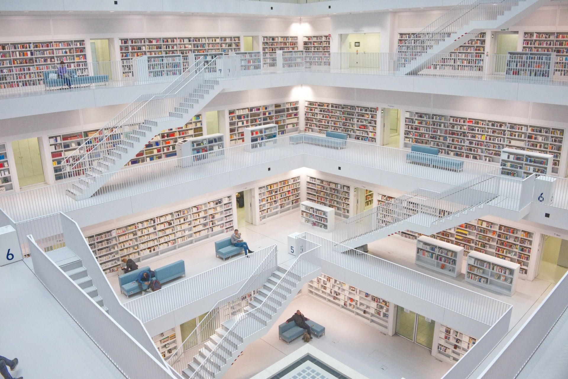 Bibliothèque sur plusieurs étage, blanche et lumineuse, avec des escaliers et des lecteurs isolés - Photo de Niklas Ohlrogge sur https://unsplash.com/fr/photos/j-0olYcaihg