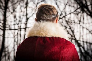 De dos, un jeune homme en costume de prince avec une couronne faite d'une dangereuse lame de scie à bois - Photo de Paweł Furman sur https://unsplash.com/fr/photos/jo21H-4lYFU