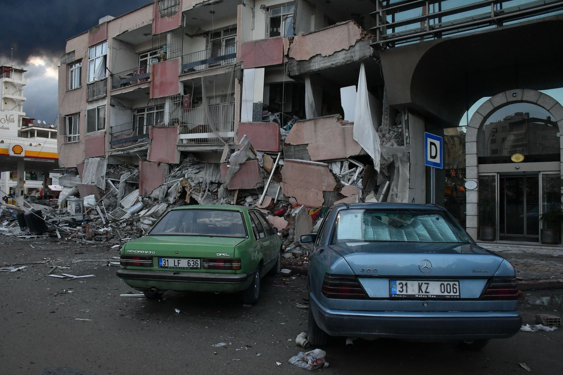 Deux voitures garées devant un immeuble à moitié détruit par un tremblement de terre en Turquie - Photo de Çağlar Oskay sur https://unsplash.com/fr/photos/quelques-voitures-garees-devant-un-immeuble-Lva3ACKlL_8