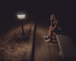 Une femme triste et préoccupée, assise dehors dans la nuit sur un banc en tenue de sport - Photo de Jackson Simmer sur https://unsplash.com/fr/photos/isVYj70Ar-E
