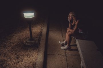 Une femme triste et préoccupée, assise dehors dans la nuit sur un banc en tenue de sport - Photo de Jackson Simmer sur https://unsplash.com/fr/photos/isVYj70Ar-E