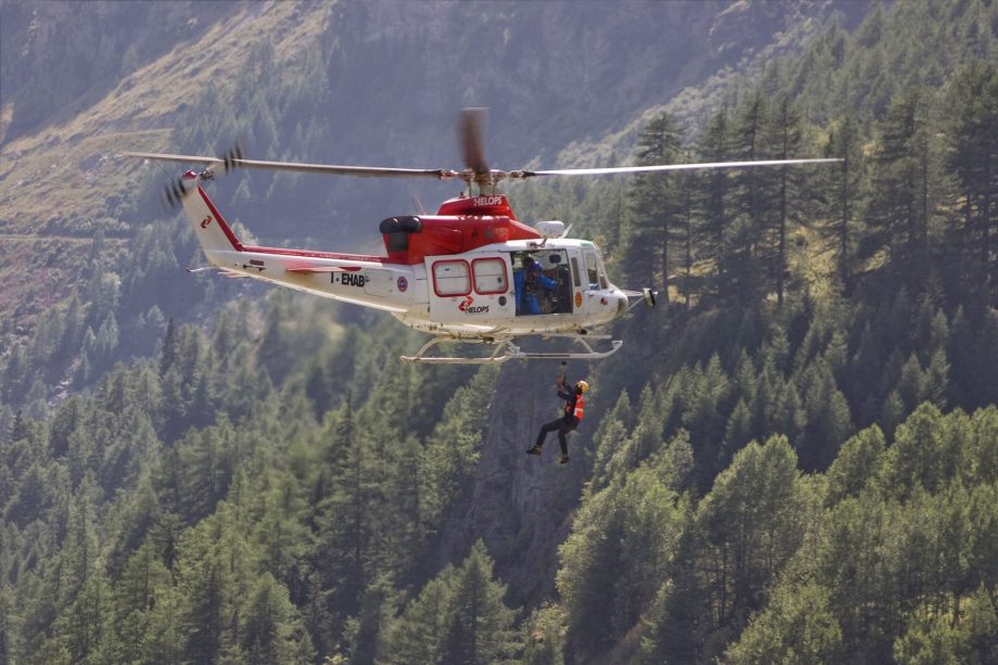 Un hélicoptère en montagne treuille un secouriste au dessus d'une forêt - Image par Sergio Cerrato - Italia de https://pixabay.com/fr/photos/h%C3%A9licopt%C3%A8re-montagne-5363389/