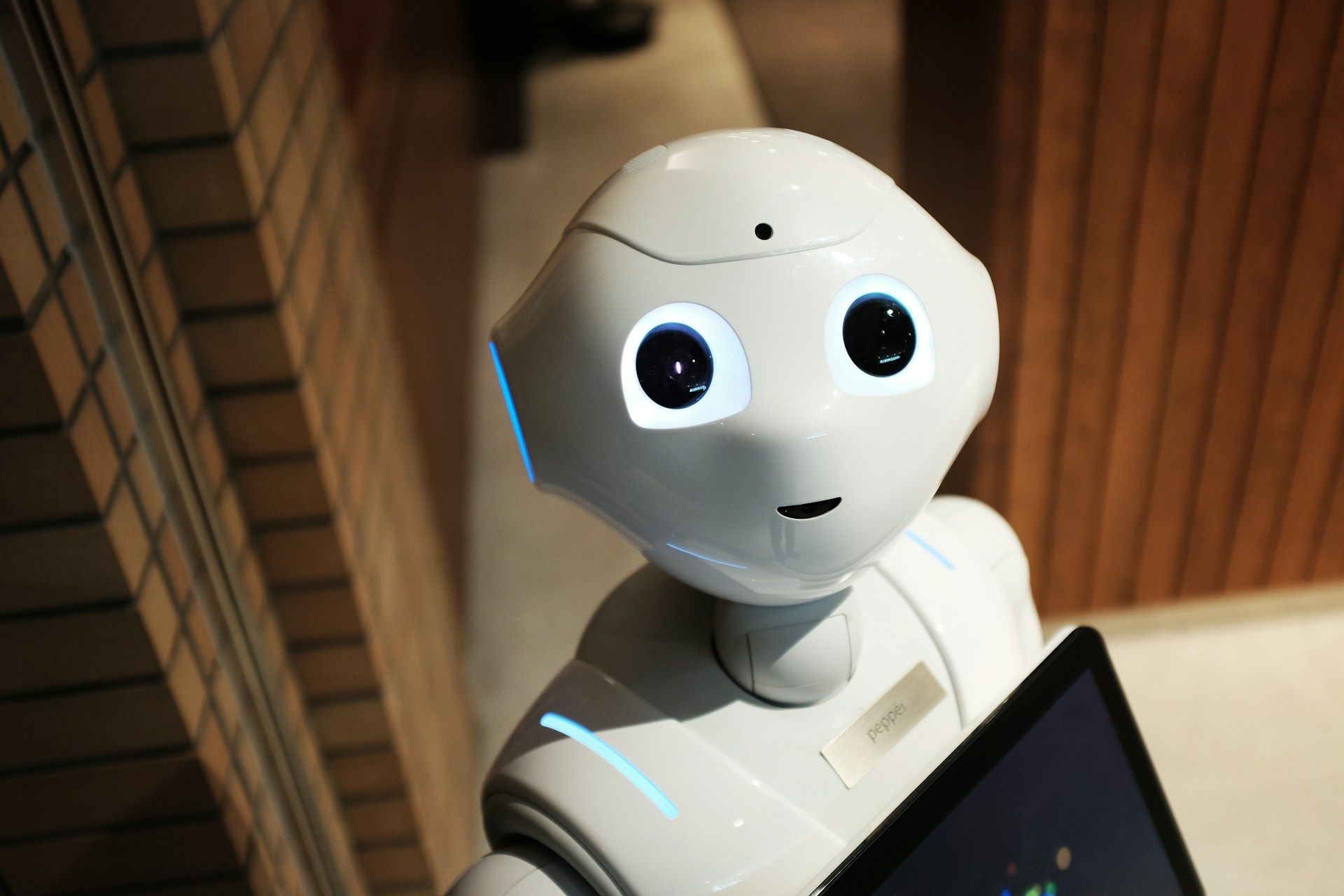 Un robot avec de grznds yeux sympathiques - Photo de Alex Knight sur https://unsplash.com/fr/photos/robot-blanc-pres-dun-mur-brun-2EJCSULRwC8