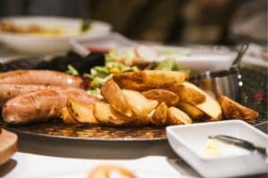 Un plat de saucisses grillées, de pommes de terre et de salade - Photo de Luna Wang sur https://unsplash.com/fr/photos/une-assiette-de-nourriture-avec-des-saucisses-des-pommes-de-terre-et-de-la-salade-KEs360uEST4