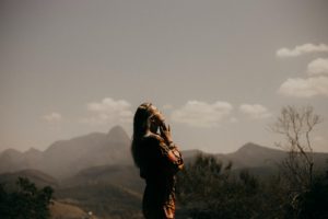 Femme priant debout dans la nature, au crépuscule - Photo de Marcos Paulo Prado sur https://unsplash.com/fr/photos/femme-en-veste-noire-debout-sur-le-champ-dherbe-verte-pendant-la-journee-LlrQF5JFRIs