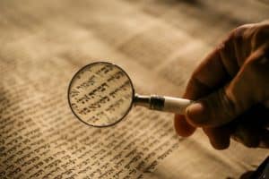 Un texte de la Bible en hébreu, regardé avec une loupe - Photo de Mick Haupt sur https://unsplash.com/fr/photos/personne-tenant-une-loupe-eQ2Z9ay9Wws