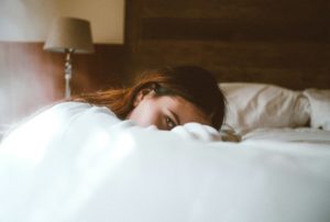 Une femme ouvre un œil, à moitié sur le lit - Photo de Bruno van der Kraan sur https://unsplash.com/fr/photos/femme-reposant-sa-tete-sur-le-lit-i4rOpdj444c