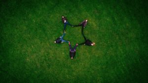 Vu du ciel, cinq amis allongés dans l'herbe forment une étoile - Image par Pexels de https://pixabay.com/fr/photos/adultes-copains-formation-gazon-1853483/